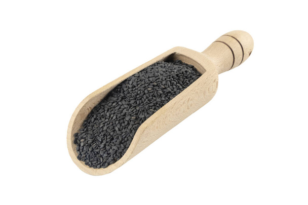 Czarne nasiona sezamu w drewnianej gałce wyizolowane na białym tle. Przyprawy i składniki żywności. - Zdjęcie, obraz