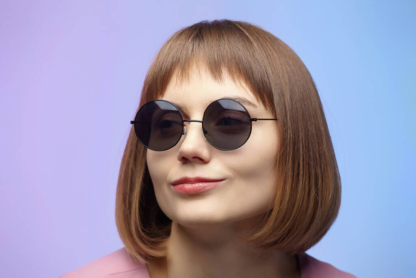 stylish girl in sunglasses. photo shoot in the studio on a pink background - Φωτογραφία, εικόνα