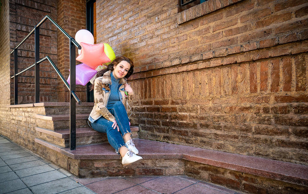 happy woman with balloons on the street - Фото, изображение