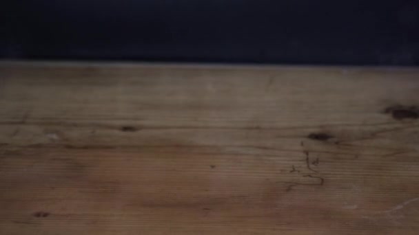 Dampf und Flüssigkeit aus spritzendem Kaffee auf Holztisch mit schwarzem Hintergrund - Filmmaterial, Video
