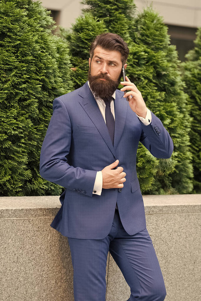 Business communication. Mobile technology. Business call. Stylish guy wear tuxedo. Stay connected. Businessman talk mobile phone. Handsome bearded man with cell phone outdoor. Mobile lifestyle - Fotoğraf, Görsel