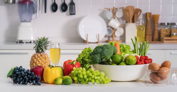 healthy and vegetarian foods background and banner of arrangement of fruits, vetgetables and eggs on white table in kitchen - Photo, image