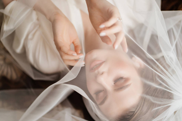 view top. a beautiful young woman in robe is lying under a veil. - Fotografie, Obrázek