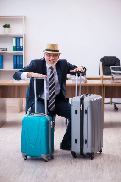 Vecchio dipendente maschile che si prepara per viaggiare in ufficio - Foto, immagini