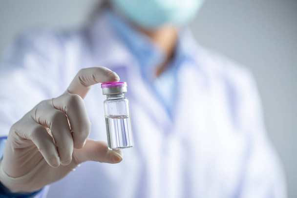 Γιατρός ή επιστήμονας κρατώντας φύσιγγα υγρά εμβόλια με φαρμακευτική αγωγή στο εργαστήριο. Εμβολιασμός και ανοσοποίηση. Κλείσε.. - Φωτογραφία, εικόνα