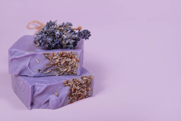 Handgemachte hausgemachte Seife auf fliederfarbenem Hintergrund. Lavendelduft. Kleinunternehmen, Bioprodukte, natürliche Zutaten. - Foto, Bild