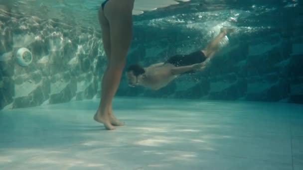 Podwodne nagranie człowieka pływającego pod wodą w dużym odkrytym basenie - Materiał filmowy, wideo
