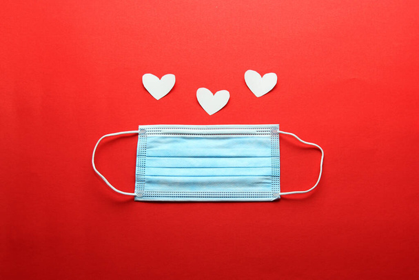 Tri-layer protective mask for clinical use with white hearts on a red background - Photo, Image
