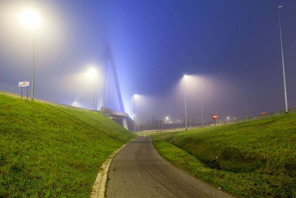 Pendant le brouillard sur une rue cyclable la nuit sur le bord d'une ville - Photo, image