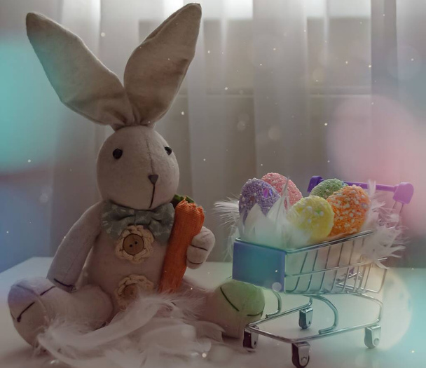 Великодня композиція іграшкового кролика з кольоровими яйцями в продуктовому кошику
. - Фото, зображення