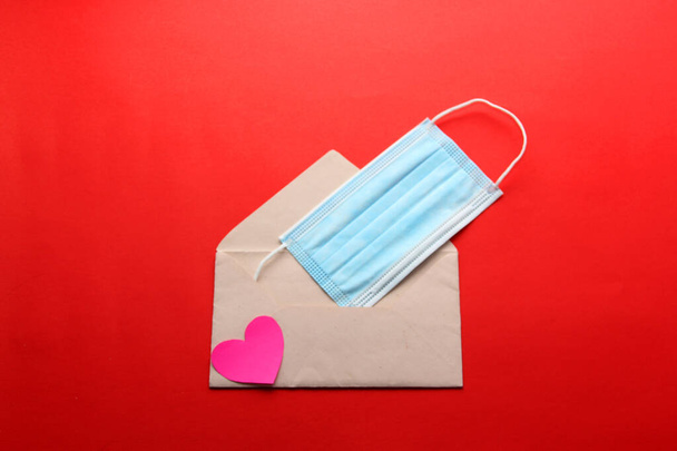 Día de San Valentín en pandemia por covid-19, mensajes y cartas de amor con máscara de protección uso clínico y corazones rosados - Foto, imagen