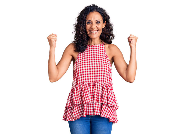 Middle age beautiful woman wearing casual sleeveless t shirt screaming proud, celebrating victory and success very excited with raised arms  - Photo, Image