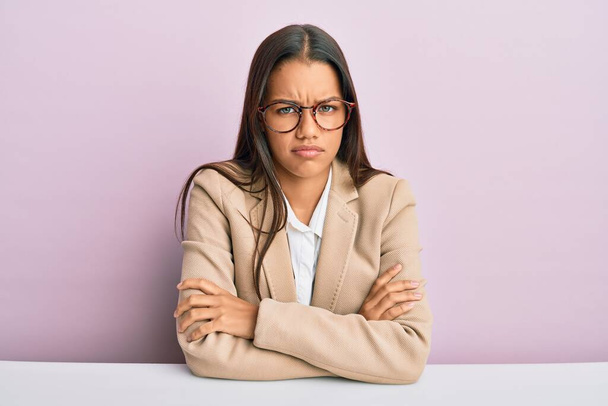 Beautiful hispanic woman working at the office skeptic and nervous, disapproving expression on face with crossed arms. negative person.  - Photo, Image
