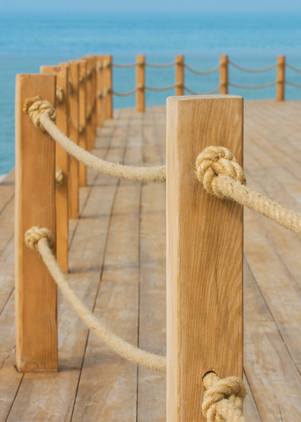 Plataforma de madeira na praia. Pinos de madeira ligados por cordas de cânhamo. Bela vista do mar calmo. - Foto, Imagem