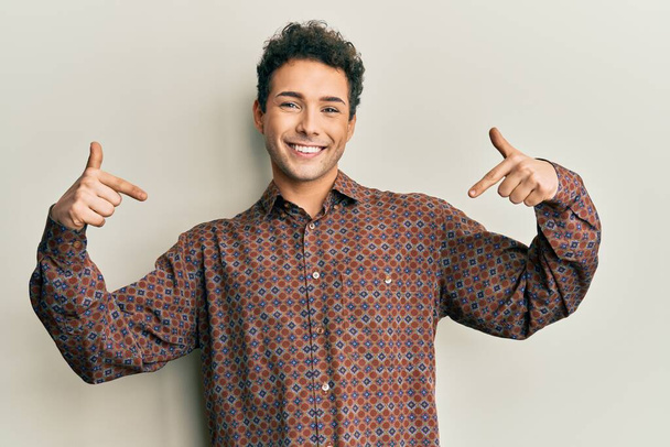 Hombre hispano guapo vistiendo ropa casual mirando confiado con sonrisa en la cara, señalándose con los dedos orgullosos y felices.  - Foto, imagen