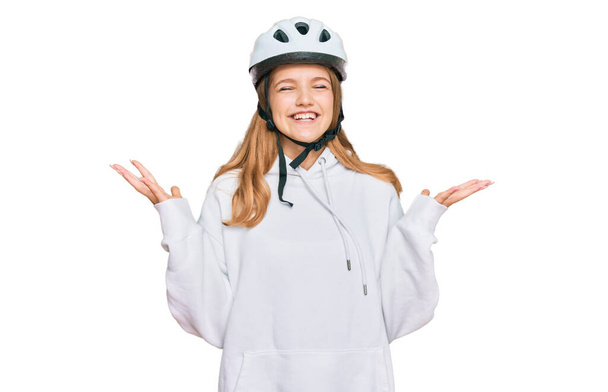 Hermosa chica caucásica joven con casco de bicicleta celebrando loco y loco por el éxito con los brazos levantados y los ojos cerrados gritando emocionado. concepto ganador  - Foto, Imagen