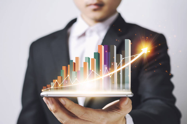 Businessmen Asia  holding Smartphone and showing a growing virtual hologram of statistics, graph and chart with arrow up on white background. Stock market. Business growth, planing concept. - Photo, Image