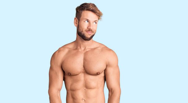 Young caucasian man standing shirtless smiling looking to the side and staring away thinking.  - Photo, Image