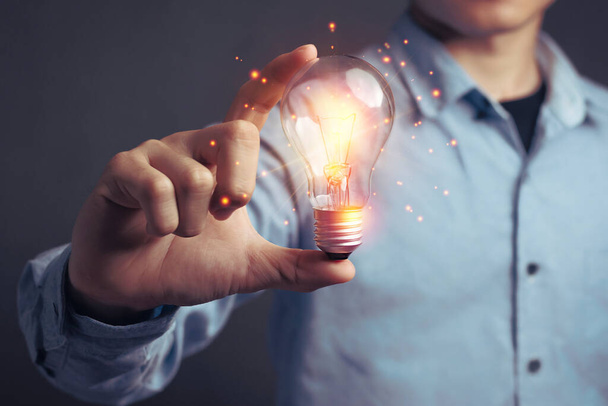 Man holding light bulbs, ideas of new ideas beautiful creative and communicate the new inventions with innovative technology and creativity. concept creativity with bulbs that shine glitter - Photo, Image