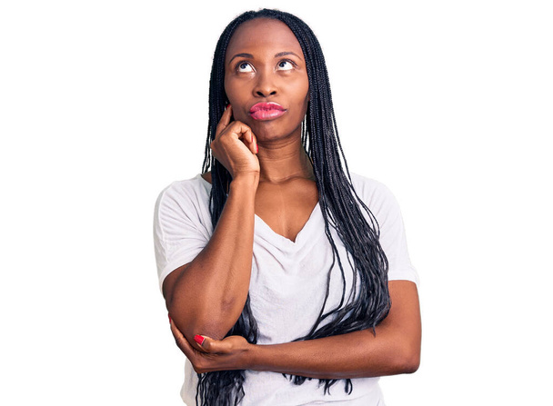 Fiatal afro-amerikai nő alkalmi ruhát visel komoly arc gondolkodás kérdés kézzel az állon, gondolkodó zavaros ötlet  - Fotó, kép