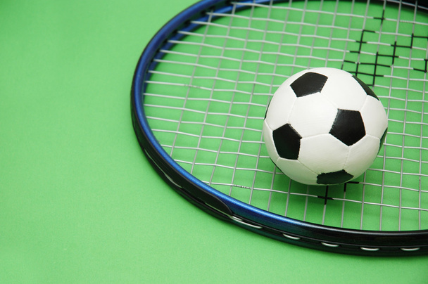 Футбольна та тенісна ракетка на зеленому фоні
 - Фото, зображення