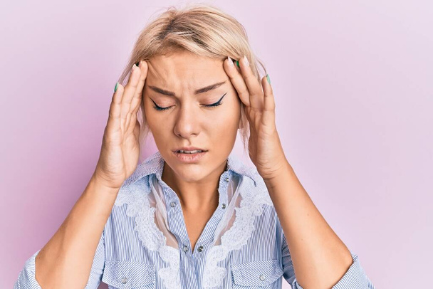 Junge blonde Mädchen in lässiger Kleidung mit der Hand auf dem Kopf für Schmerzen im Kopf wegen Stress. Migräne.  - Foto, Bild