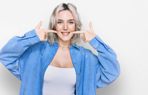 Young blonde girl wearing casual clothes smiling cheerful showing and pointing with fingers teeth and mouth. dental health concept.  - Φωτογραφία, εικόνα