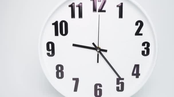 De witte klok wordt weergegeven om 9: 00 - 11: 00 uur of 21: 00 - 23: 00 uur.Wit wijzerplaat De wijzers van de klok zijn zwart. effen witte achtergrond. - Video