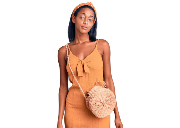 Young african american woman wearing summer outfit relaxed with serious expression on face. simple and natural looking at the camera.  - Foto, afbeelding