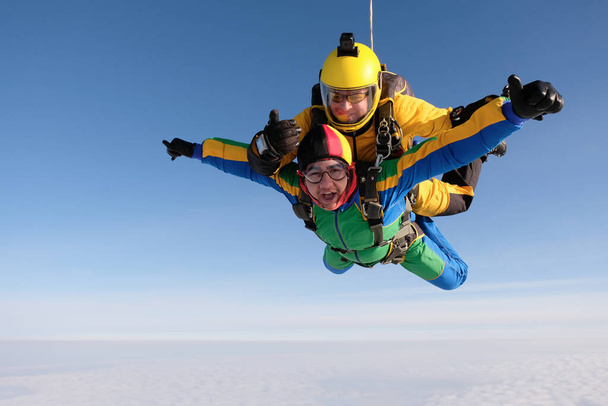 Прыжки с парашютом Тандем прыжок. Два парня летят в небе. - Фото, изображение