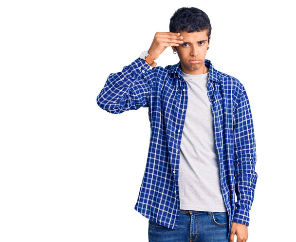 Junger afrikanisch-amerikanischer Mann in lässiger Kleidung besorgt und gestresst über ein Problem mit der Hand auf der Stirn, nervös und krisenängstlich  - Foto, Bild