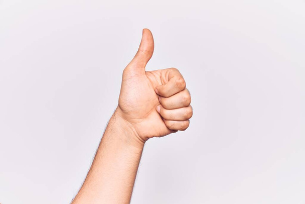 Close up of hand of young caucasian man over isolated background doing successful approval gesture with thumbs up, validation and positive symbol  - Photo, Image