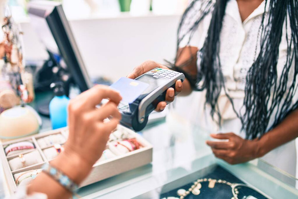 Woman paying purchase using credit card and dataphone at clothing store. - Valokuva, kuva