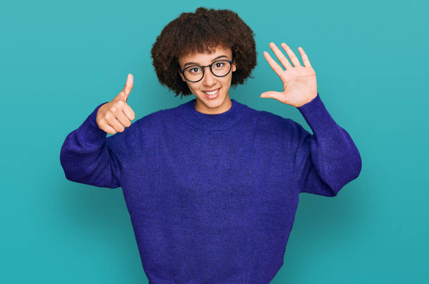 jong hispanic meisje dragen casual winter trui en bril tonen en wijzen met vingers nummer zes terwijl glimlachen zelfverzekerd en gelukkig.  - Foto, afbeelding