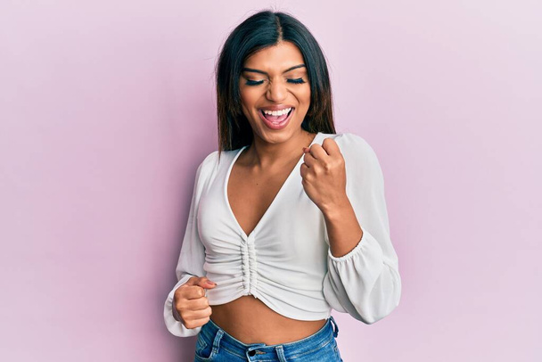 Young latin transsexual transgender woman wearing casual clothes celebrating surprised and amazed for success with arms raised and eyes closed  - Photo, Image