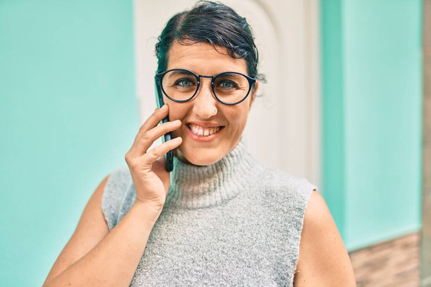 Νέοι συν μέγεθος γυναίκα χαμογελώντας ευτυχισμένη μιλώντας στο smartphone στην πόλη. - Φωτογραφία, εικόνα