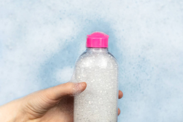 洗剤のボトルは泡に浮かんでいます。家庭用化学物質の危険性の概念。ナトリウム、受賞者パラベン、硫酸塩および泡中の他の有害化学物質。ミセル水 - 写真・画像