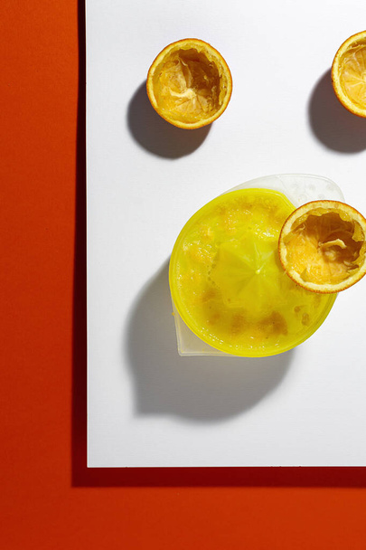 新鮮なオレンジジュースを作るために圧迫された後の色の背景にオレンジの皮 - 写真・画像