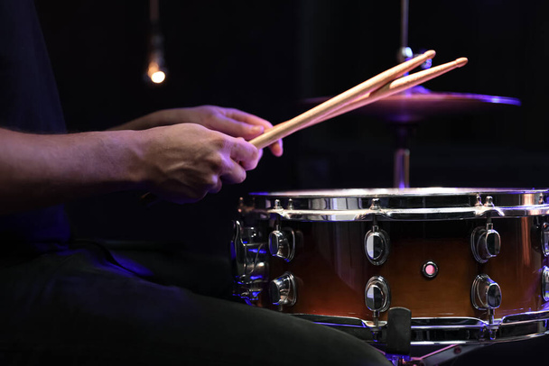 ドラムを演奏するドラマーは暗闇のスネアドラムに固執する。コンサートとライブパフォーマンスのコンセプト. - 写真・画像