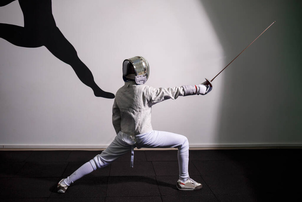 Children lunge on swords. A child in a class at a fencing school - Photo, Image