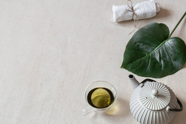カップ、ティーポット、バスアクセサリーに緑茶と最小限の組成物。健康と美の概念. - 写真・画像