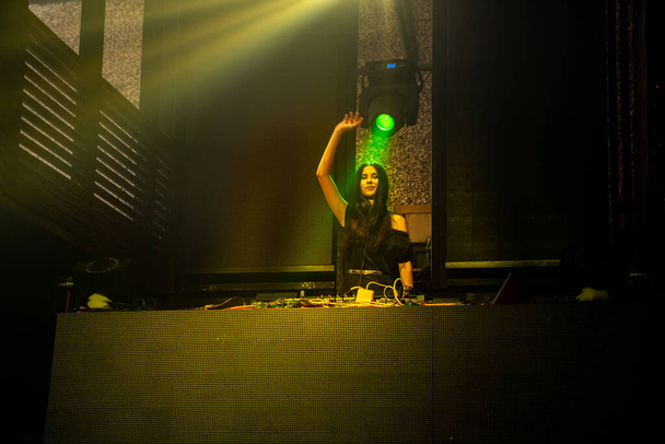 DJ on stage in disco night club mixing techno music beat - Fotó, kép