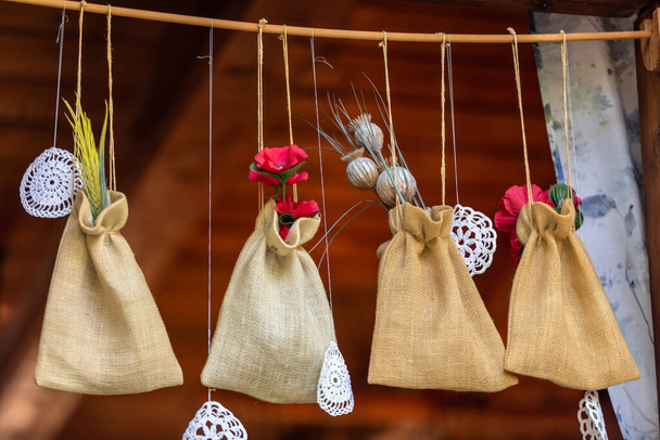Linen pouches with medicinal herbs hanging in the window of the house - Photo, Image