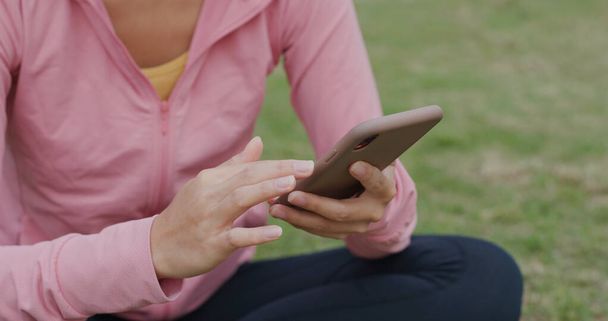 Korzystanie przez kobietę ze smartfona w parku - Zdjęcie, obraz