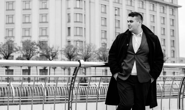 Young plus size man relaxing and enjoying the view city, plump people concept, one in big city life. Image of overweight businessman at downtown - Photo, image