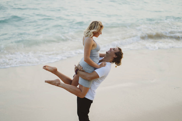 Beautiful couple dancing smiling embracing on the beach background. Valentines day on vacation. - Foto, Imagen