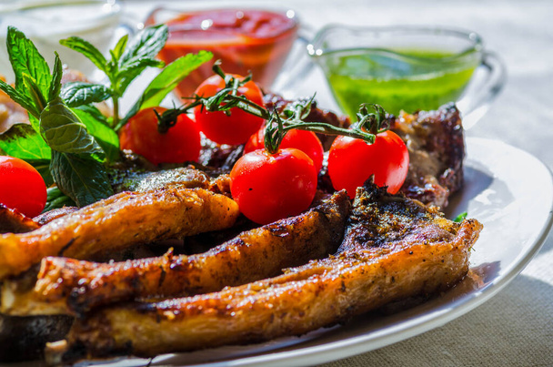 Fresh, homemade grilled beef skewers with vegetables and spices, with barbecue sauce and ketchup, on a white plate close-up - Zdjęcie, obraz
