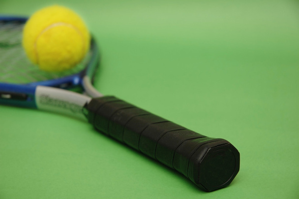 Racchetta da tennis e palla su sfondo verde
 - Foto, immagini