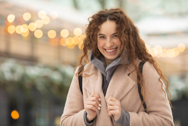 attractive smiling young woman posing on street at wintertime - Photo, image