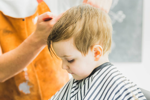 Un niño en un salón de peluquería - Foto, imagen